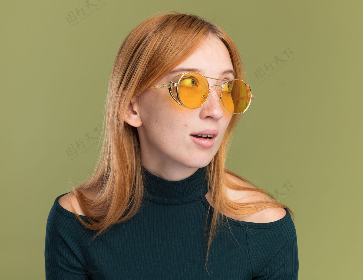 太阳高兴的年轻红发姜姑娘带着雀斑在太阳眼镜边看雀斑眼镜壁板