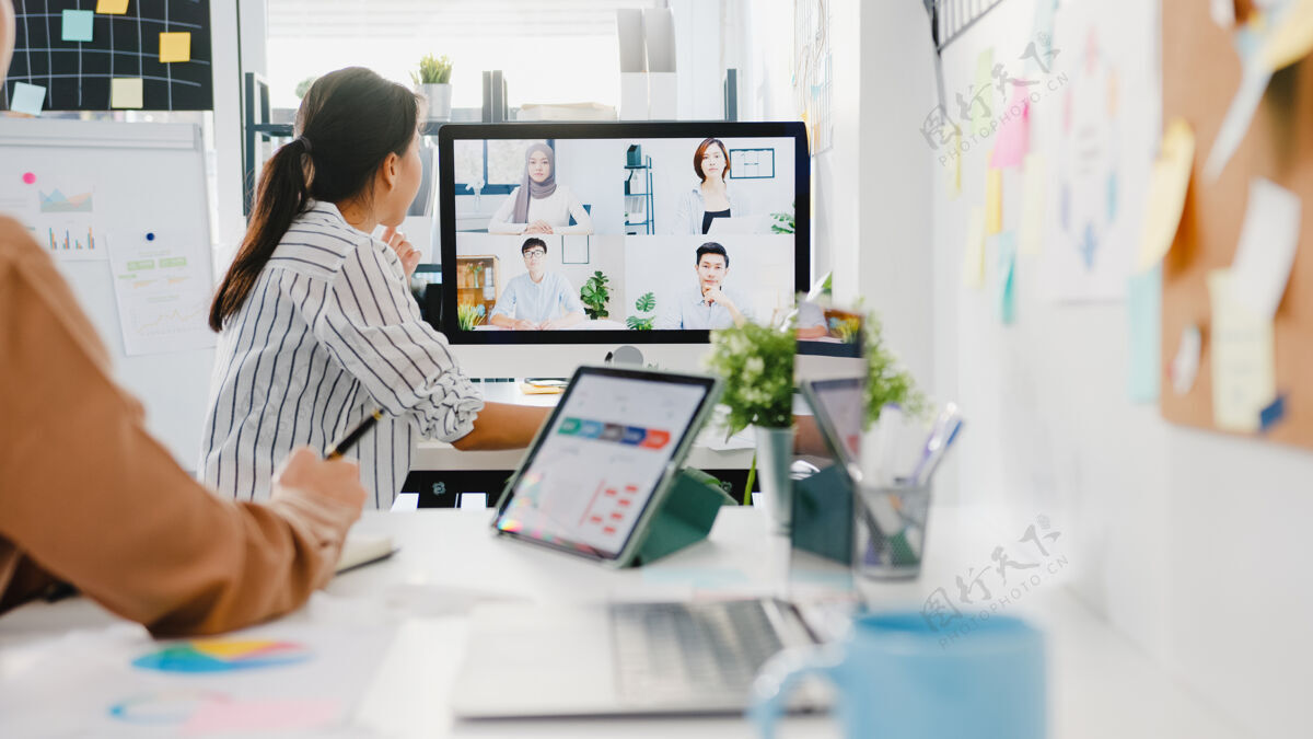 视频通话在新常态办公室的视频电话会议上 亚洲商务人士使用桌面与同事讨论关于计划的商业头脑风暴创业远程