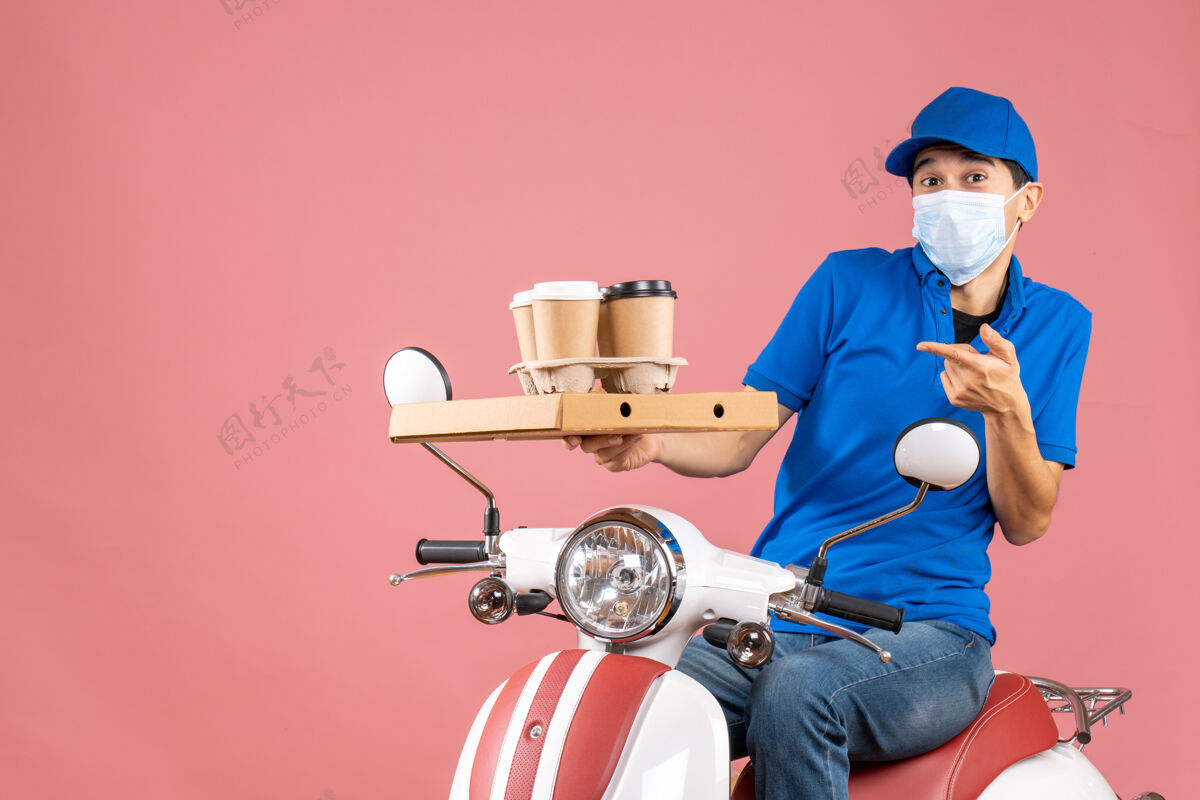 面具顶视图困惑惊讶的男性送货员戴着面具戴着帽子坐在滑板车上 在桃色背景下送货摩托车惊喜交付人