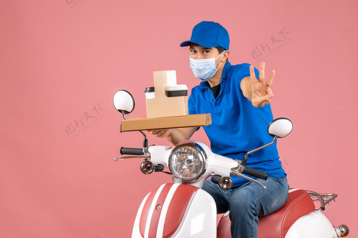 显示前视图中的男性送货员戴着口罩 戴着帽子 坐在滑板车上送货 在柔和的桃色背景上显示三个命令背景面具