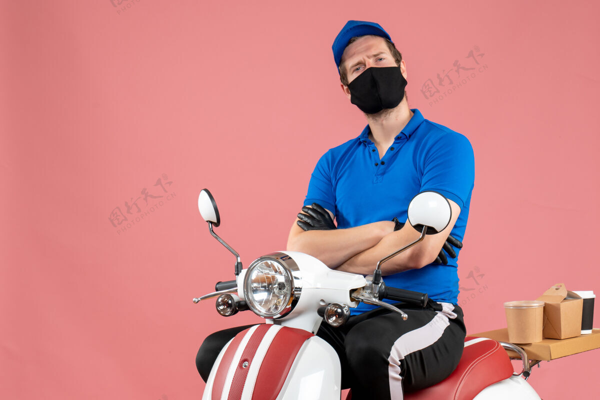 面具正面图男快递员穿着蓝色制服 戴着粉色病毒面罩骑自行车工作快递快餐服务工作蓝色病毒视图