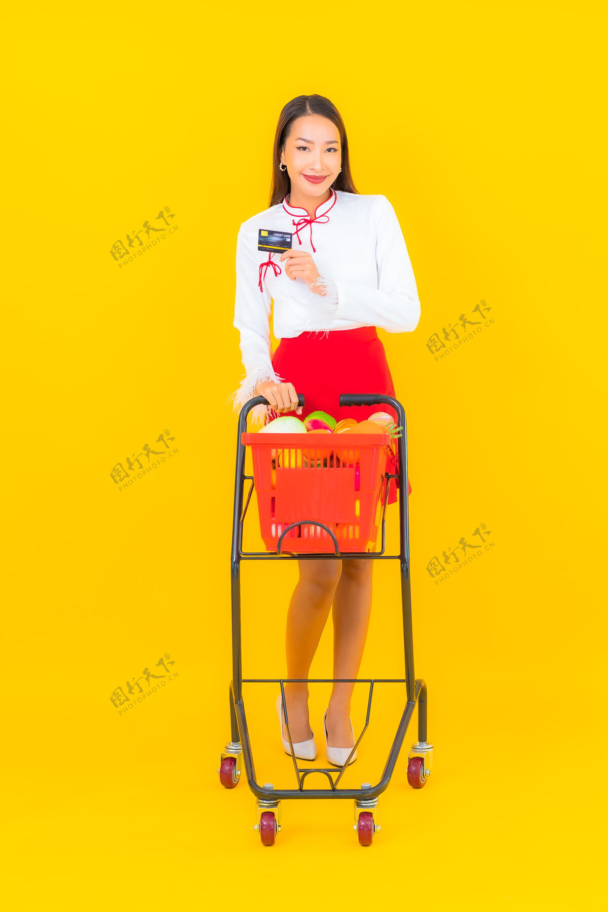 女性一幅美丽的亚洲年轻女子的画像 黄色的是超市里的购物篮休闲购买超市