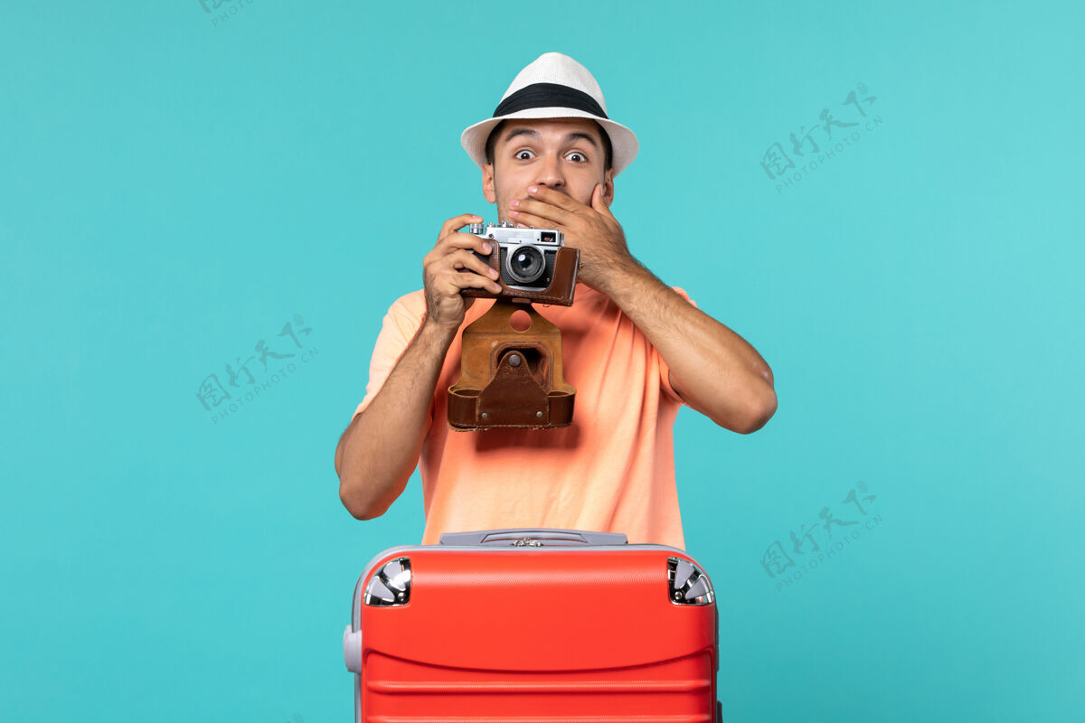 红色带着红色手提箱和蓝色相机拍照的度假男人人男性相机