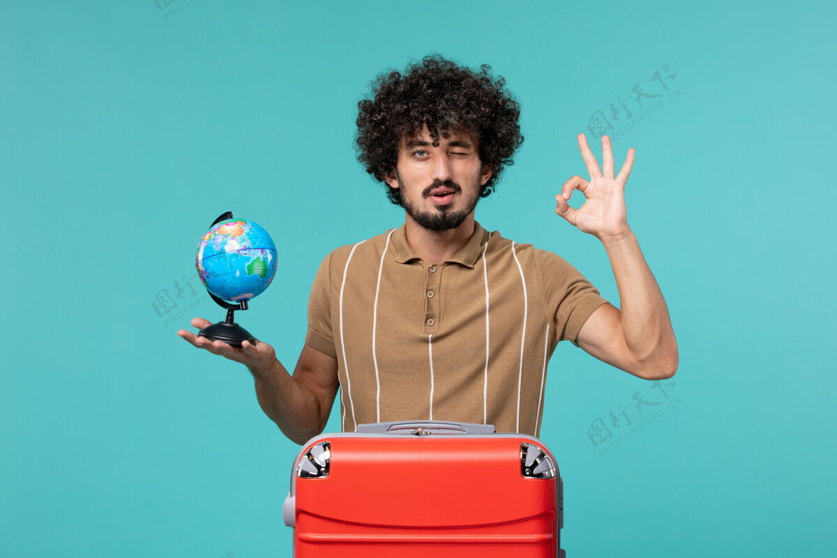 视图度假的人手里拿着一个蓝色的红色袋子的小地球仪旅行举行旅行