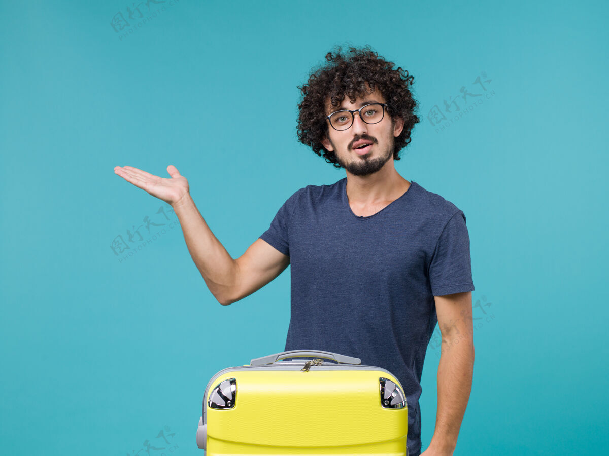 包带着蓝色大黄色手提箱的度假男人肖像假期人