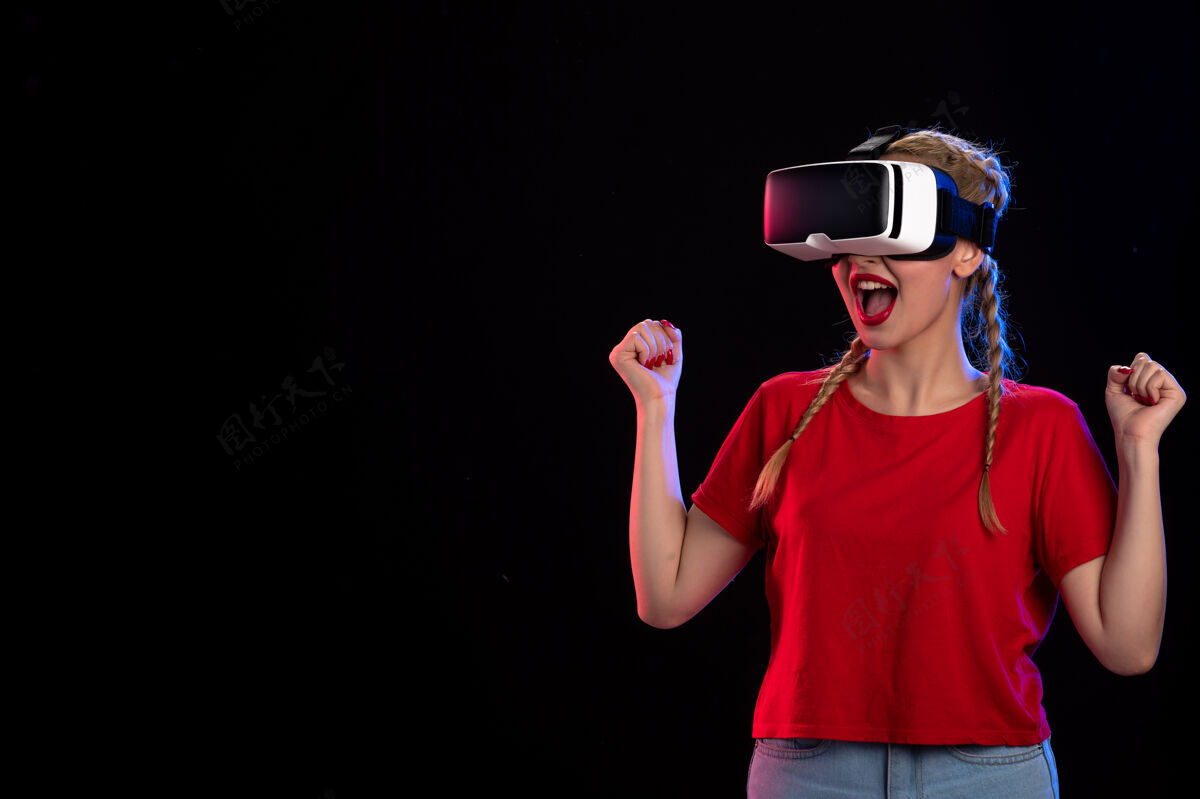 视觉年轻女性在黑暗的墙上玩虚拟现实的正面图成人年轻女性游戏