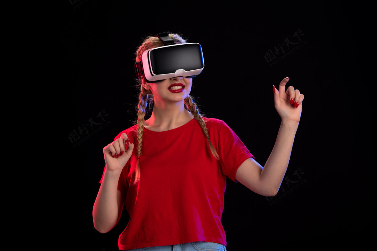 游戏年轻女性在黑暗的墙上玩虚拟现实的正面图护目镜成人虚拟现实