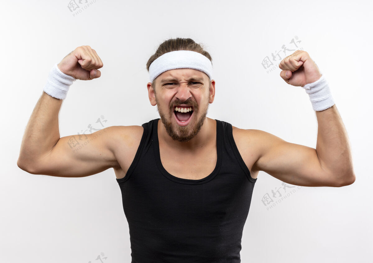 腕带自信的年轻帅气的运动型男人戴着头带和腕带在白色的墙上做着强烈的孤立的手势运动佩戴强壮