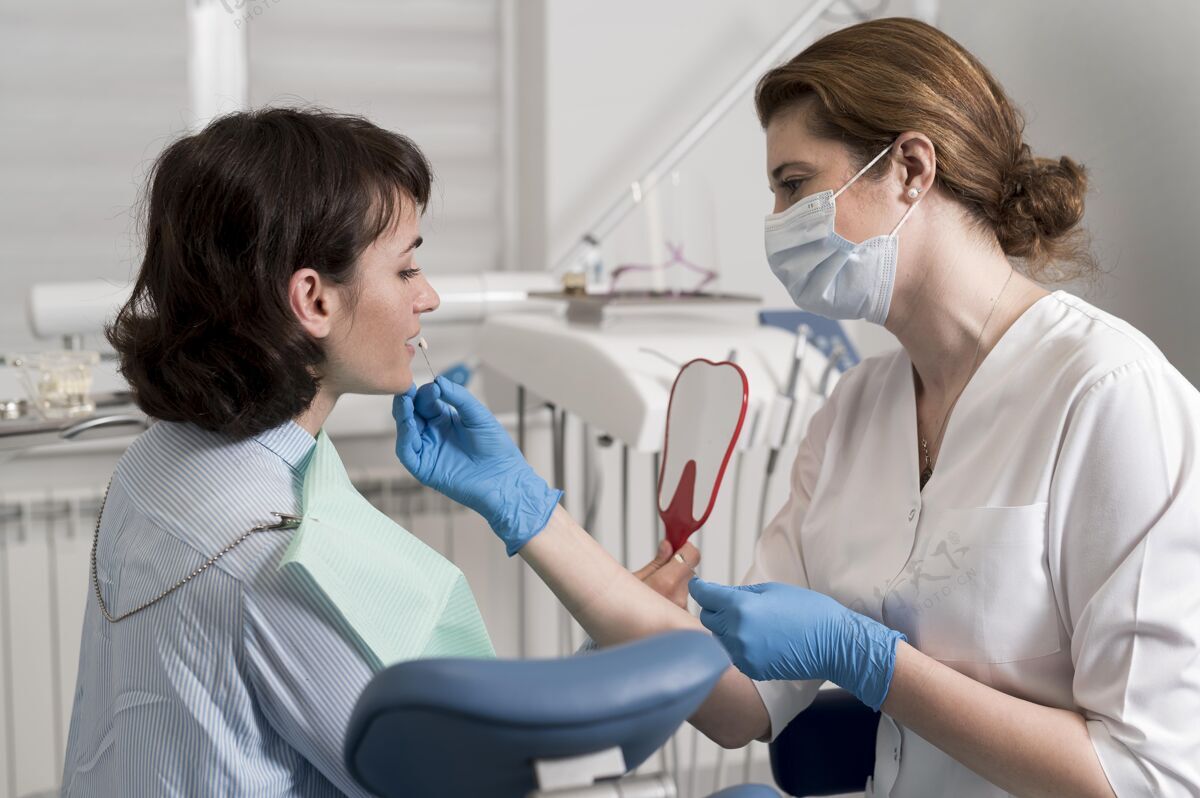 从业者女病人在牙科诊所照镜子工作面罩医疗
