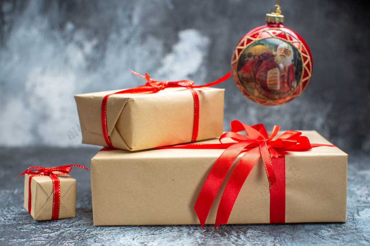 年份前视圣诞礼物用红色蝴蝶结系在浅色深色新年照片上节日彩色礼物圣诞礼物枕头礼物