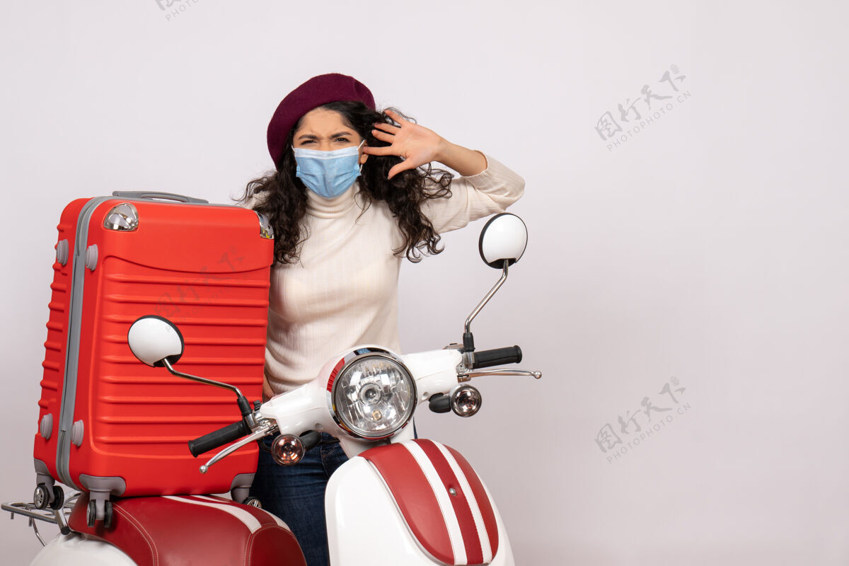 人前视图年轻女性戴着面罩骑在白色背景色covid上的自行车-车速病毒摩托车封面女郎速度年轻女性