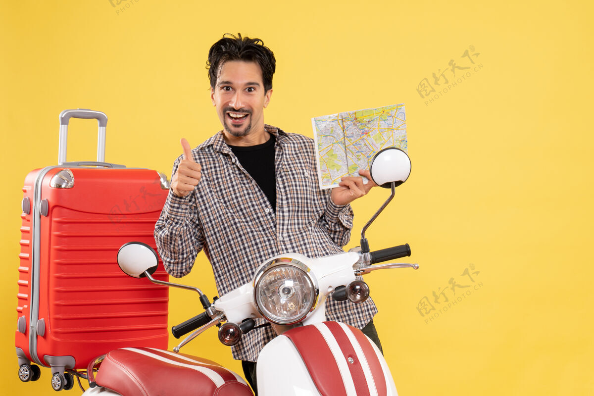 成人正面图年轻男子手握黄色背景骑自行车旅行度假骑摩托车旅行地图坐着笔记本电脑道路