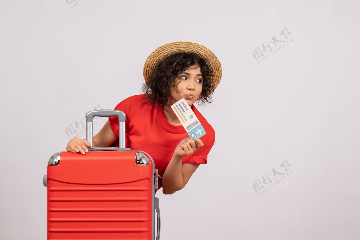 美丽正面图：年轻女性带着包准备旅行 手持白色背景色的机票 阳光下航行 度假 休息 飞机人微笑飞行