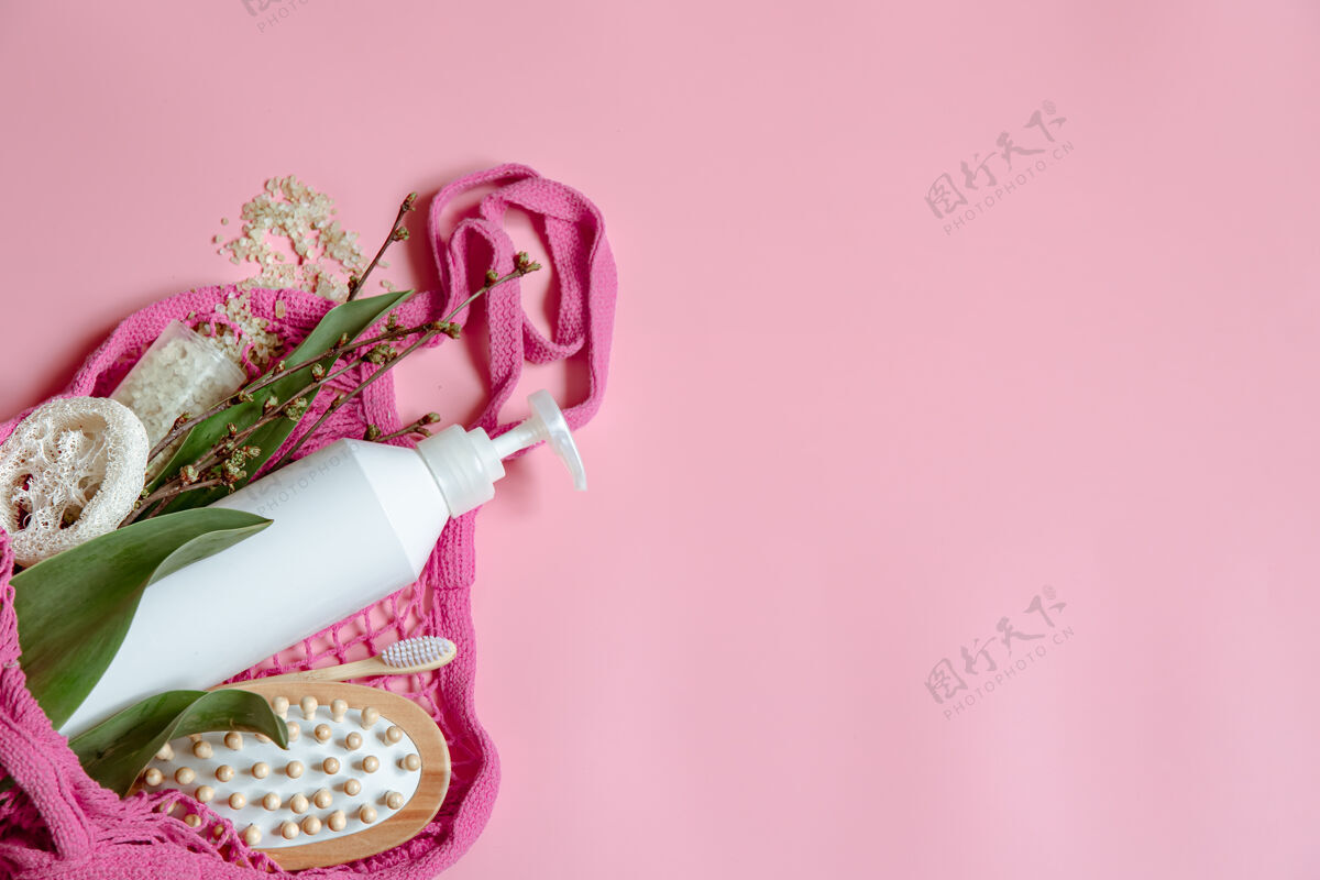 粉色平铺温泉组成与个人卫生用品和浴室配件在一个字符串袋瓶子套装绳袋