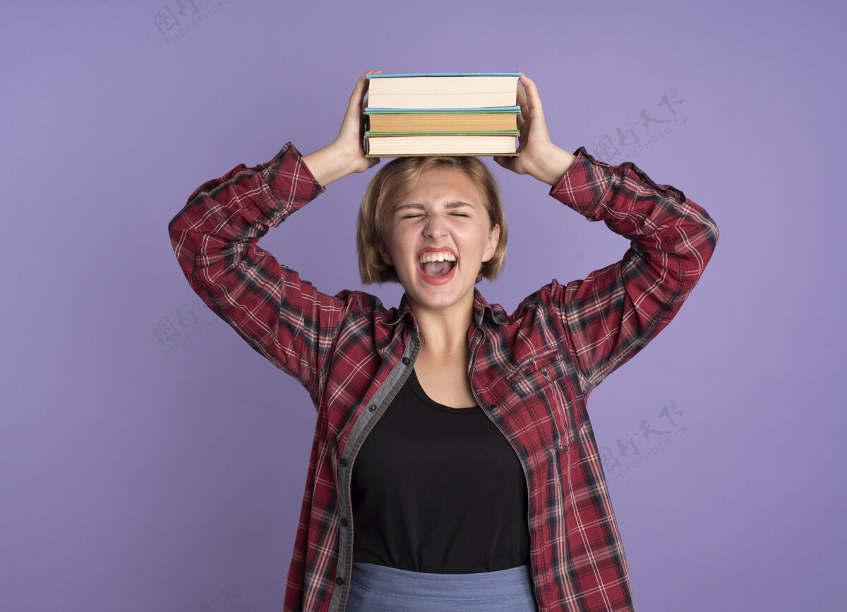 复制恼怒的年轻斯拉夫学生女孩把书举过头顶紫色学生恼怒