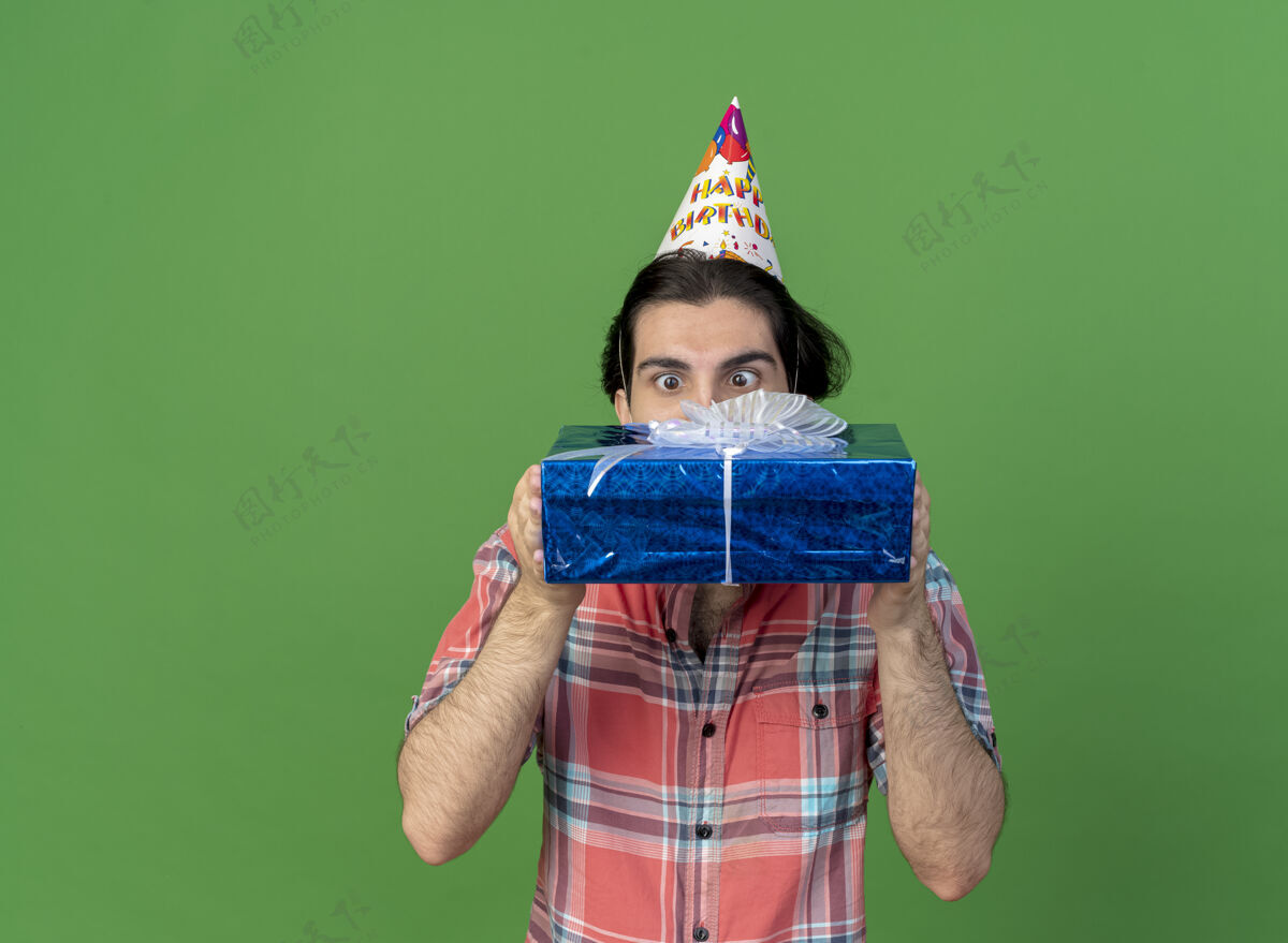 男人惊讶的白人帅哥戴着生日帽拿着礼物盒看绿色穿复制