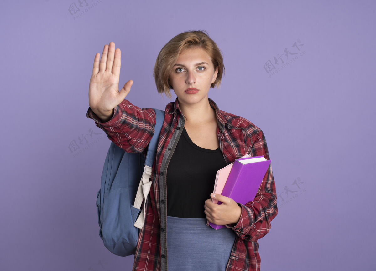 斯拉夫自信的年轻斯拉夫女学生背着书包拿着书和笔记本手势停止手势年轻停止信心