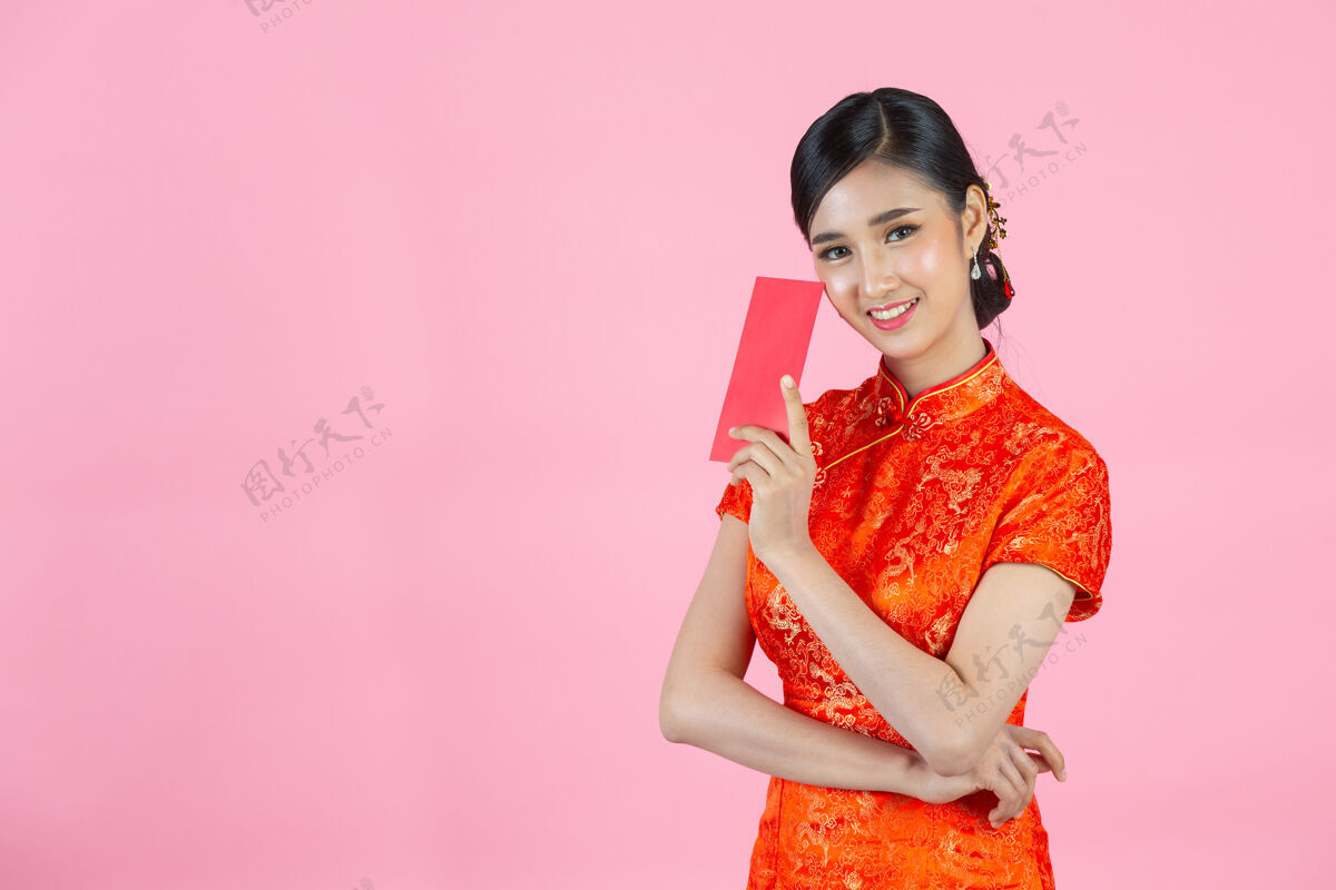 中国美丽的亚洲女人在中国的新年里展示一些东西和拿红包东方信封欢呼