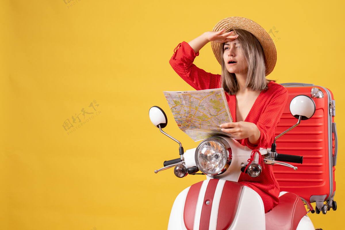 地图骑着轻便摩托车的漂亮女孩拿着红色手提箱拿着地图在看什么肖像模特时尚
