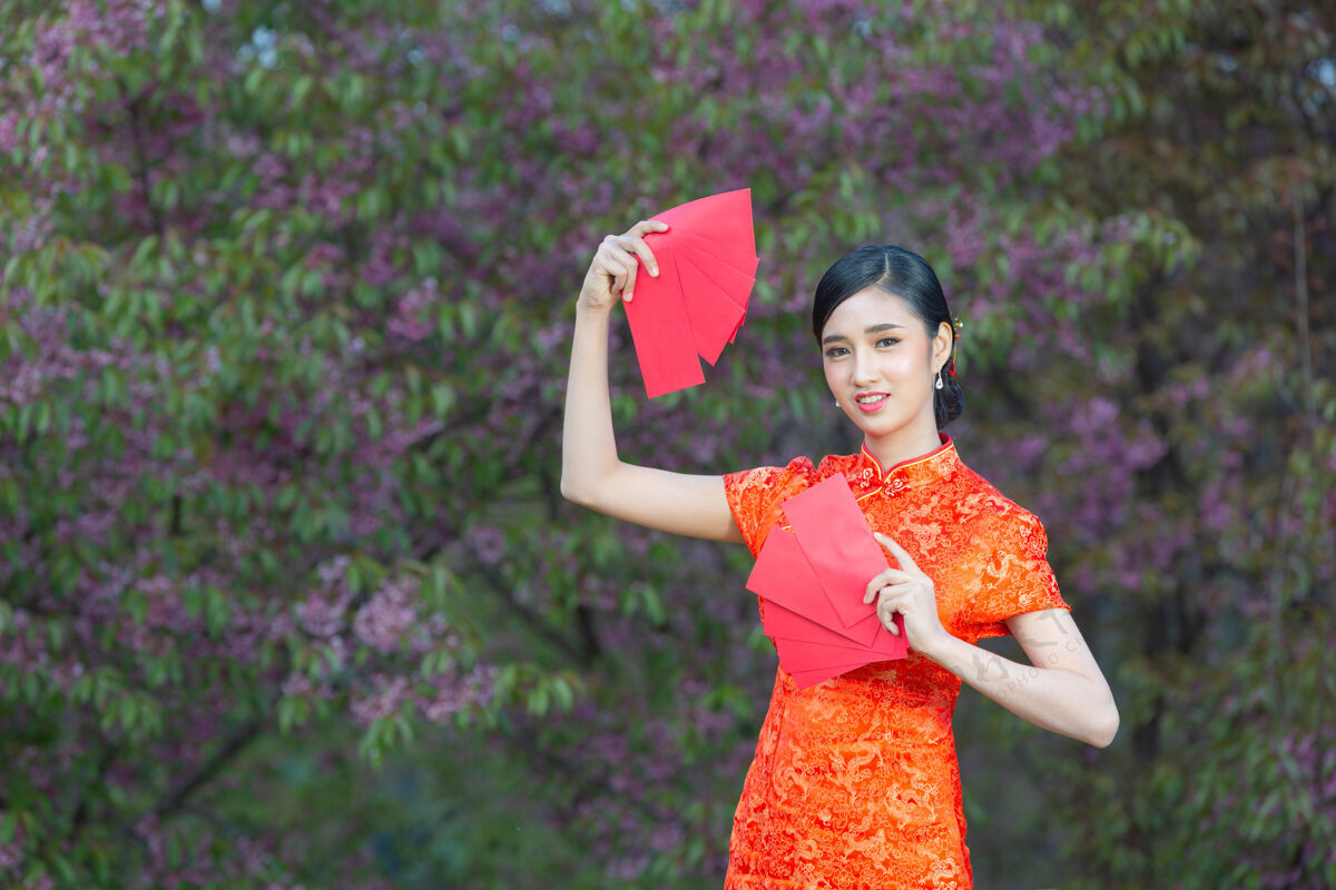 空白美丽的亚洲女人在中国的新年里展示一些东西和拿红包手势新女人