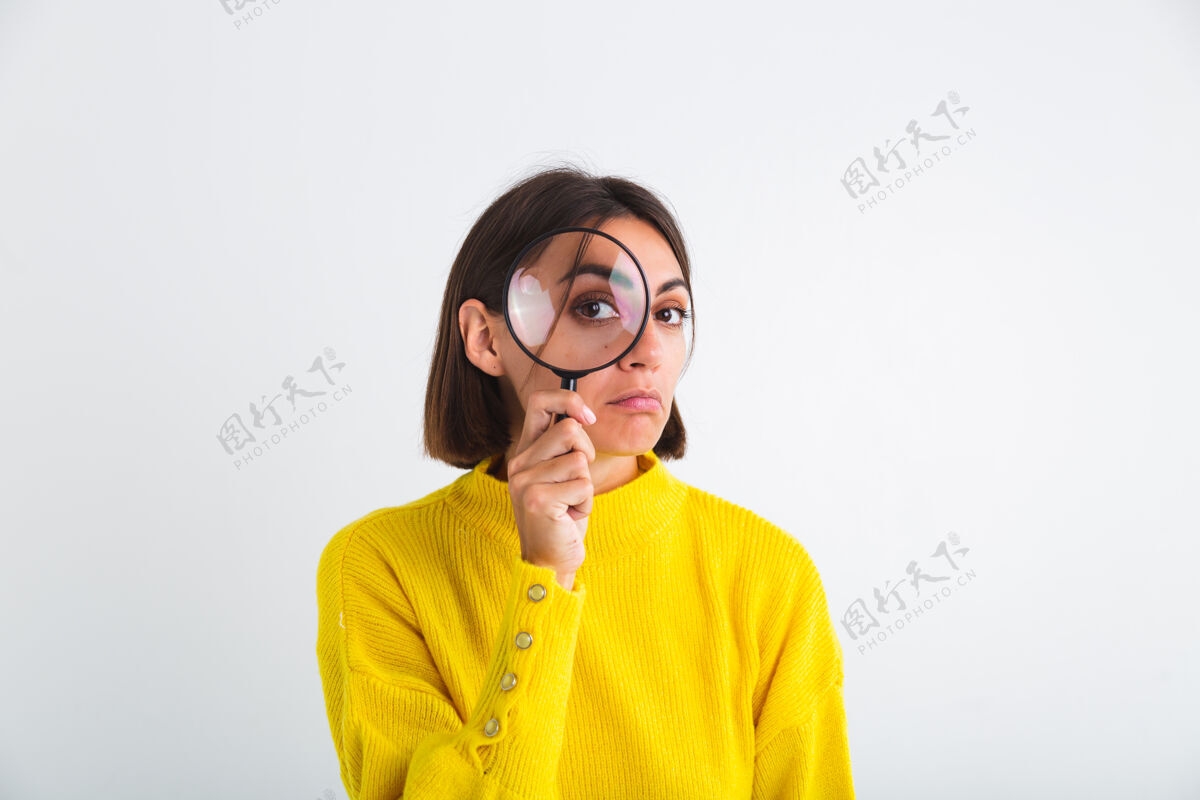 搜索穿黄色毛衣的漂亮女人拿着白色放大镜开心正好玩牙关侦探检查