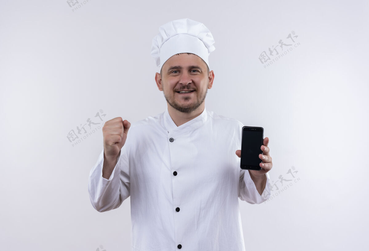 制服快乐的年轻帅哥厨师身着厨师制服手持手机举起拳头孤立在白墙上帅气手机烹饪
