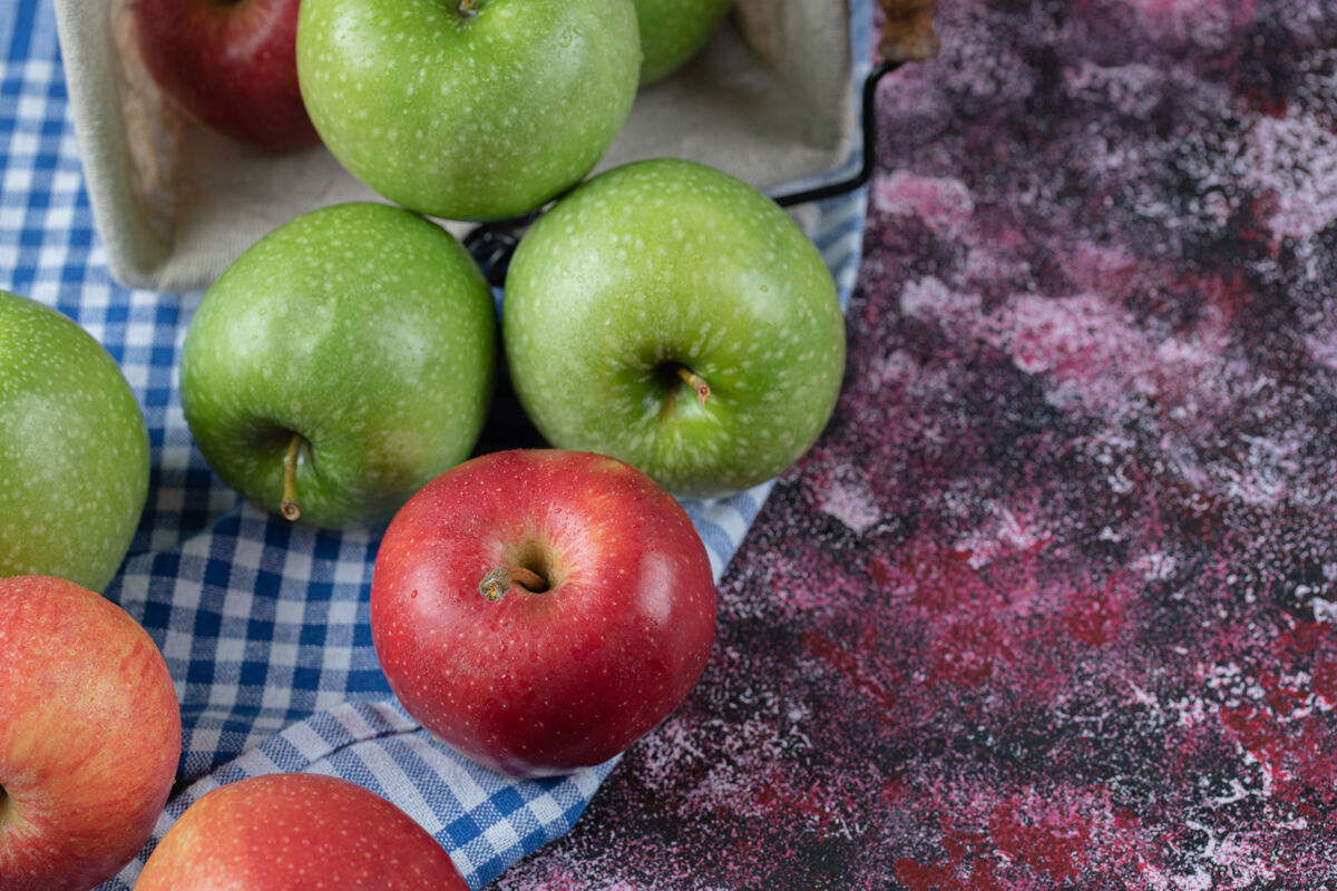 酸味红色和绿色的苹果在蓝色格子厨房毛巾上异国情调产品食物