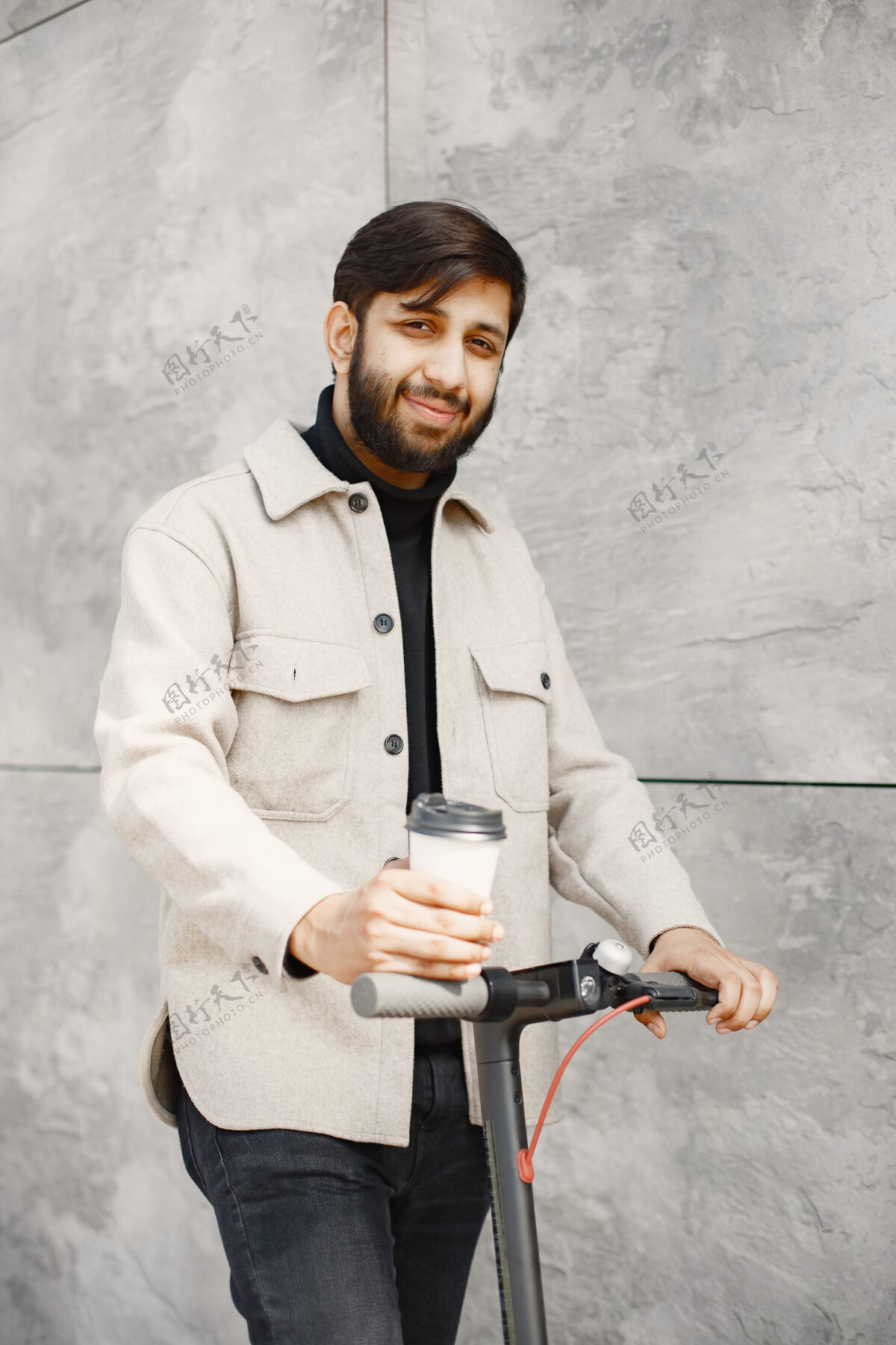 骑行印度男人骑着电动摩托车男人喝着咖啡城市摩托车白人