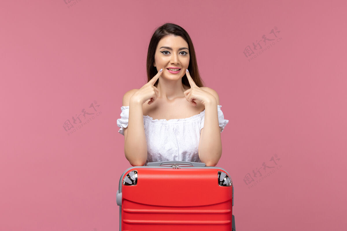 人正面图年轻女子站在粉色背景上准备度假旅行海上旅行女子出国度假头发肖像准备