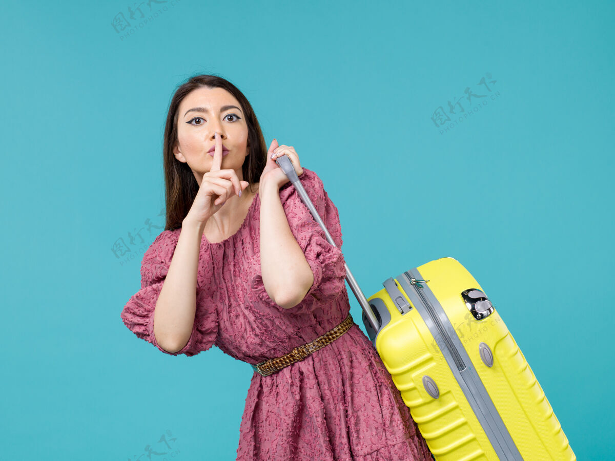 成人前景年轻女子带着她的大袋子去度假浅蓝色背景旅行夏日旅行女人海人旅行人旅行