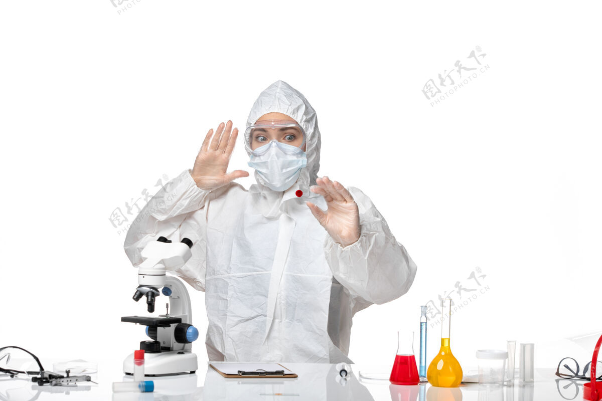 年轻女性正面图年轻女医生穿着白色防护服 戴着口罩 由于科维德工作在白色背景下大流行 飞溅病毒健康科维德药套装人
