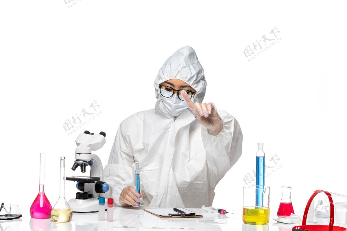 特殊正面图年轻的女化学家穿着特殊的防护服 拿着一个浅白色背景上的蓝色溶液烧瓶 科维德化学病毒实验室医学实验室医生