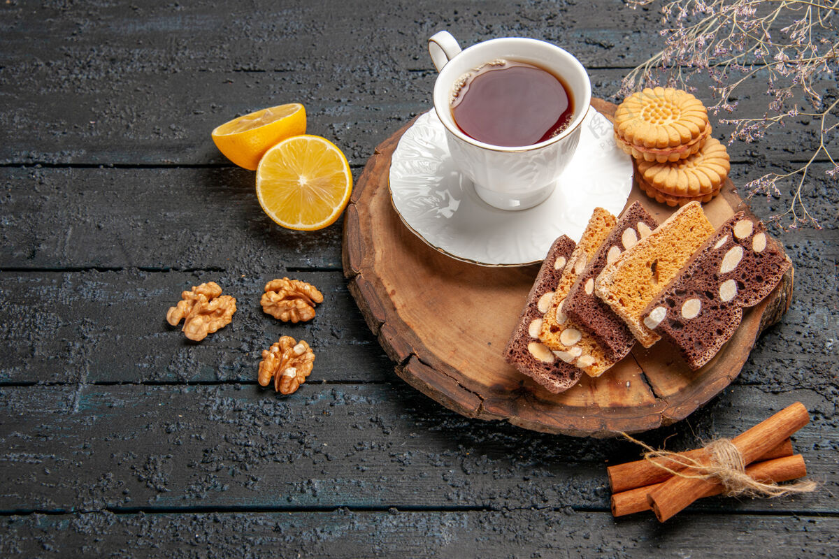 咖啡因前视一杯茶 配上饼干和水果 在黑暗的桌子上仪式甜甜的饼干糖咖啡杯子早餐