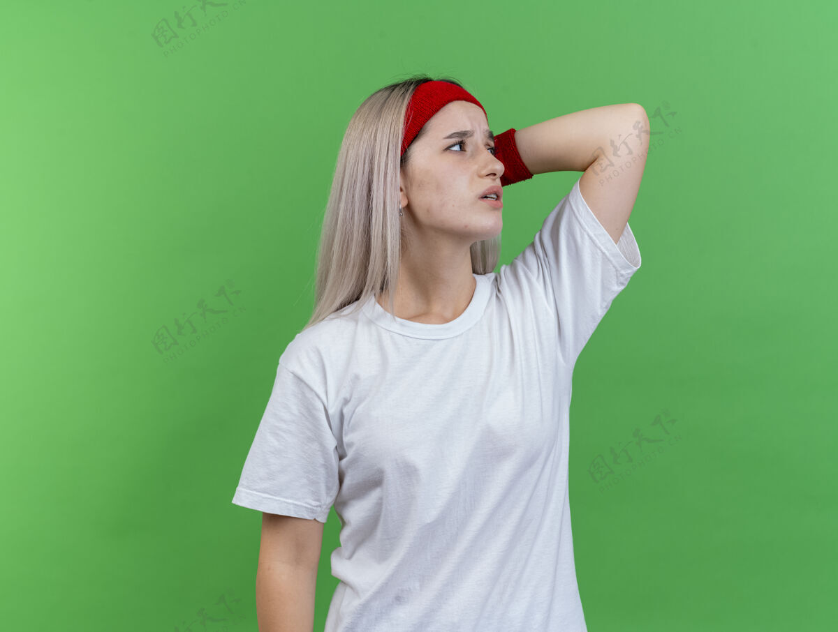 头带疼痛的年轻白人运动女孩戴着背带和头带手疼痛壁板