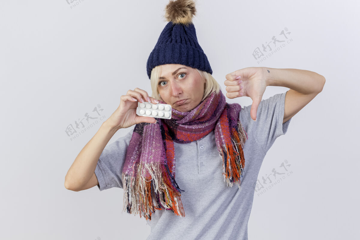 金发年轻的金发病斯拉夫女人戴着冬天的帽子和围巾不愉快帽子拇指