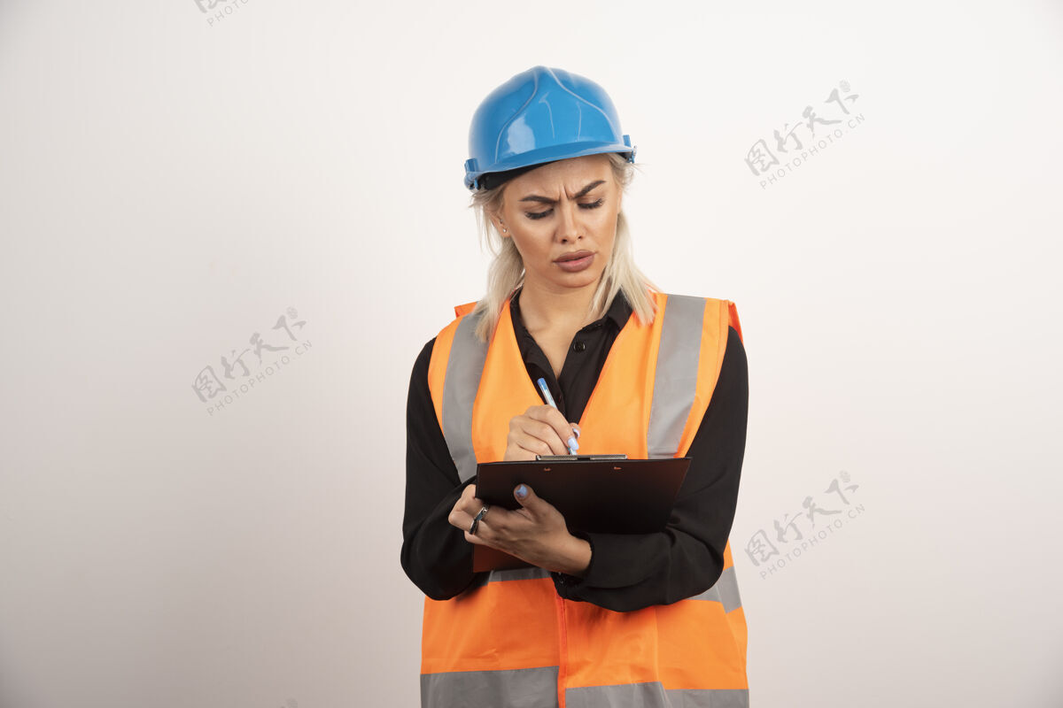 工程师女工程师在白色背景上检查笔记高质量照片女站成人