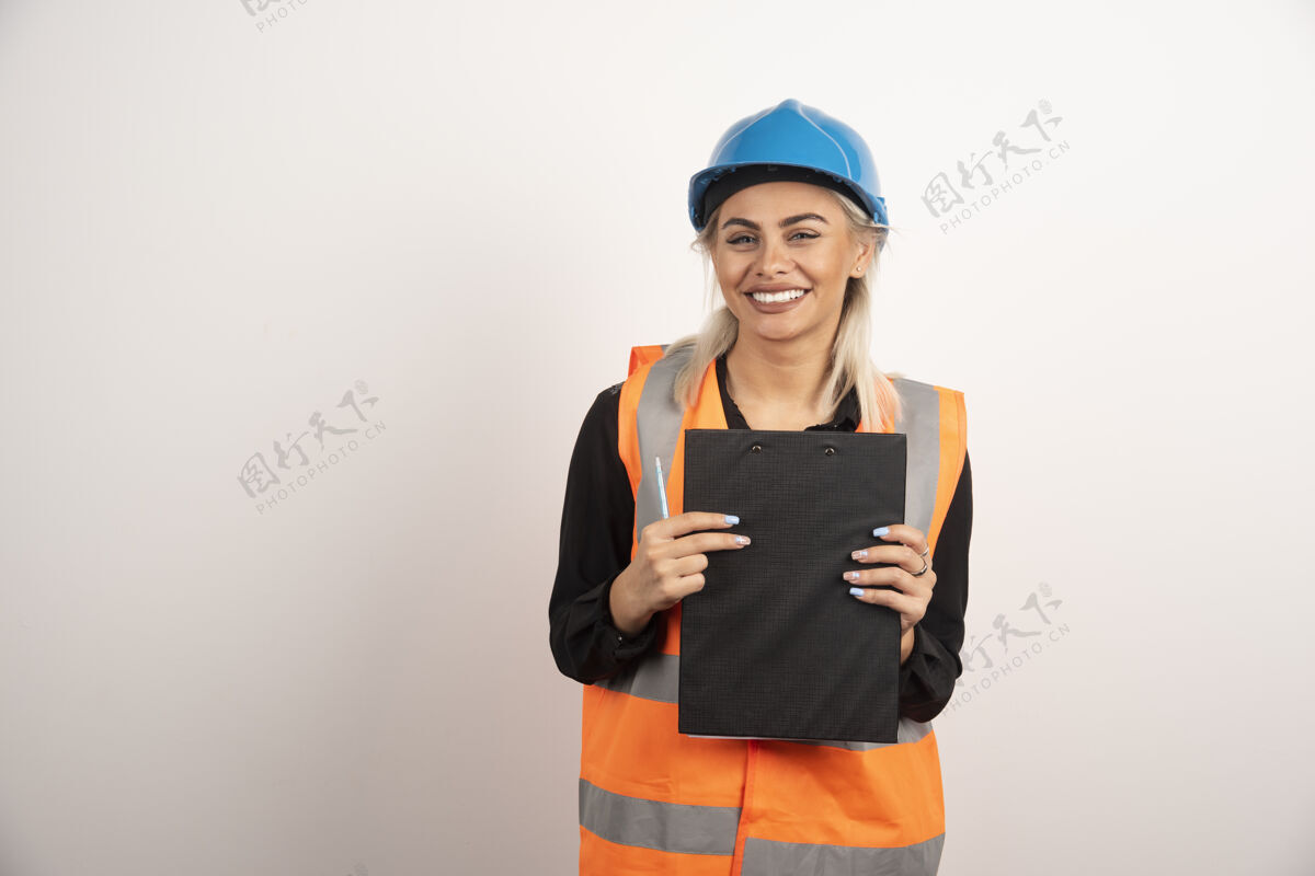 微笑女工业工人拿着白色背景的剪贴板高质量的照片人女性工人
