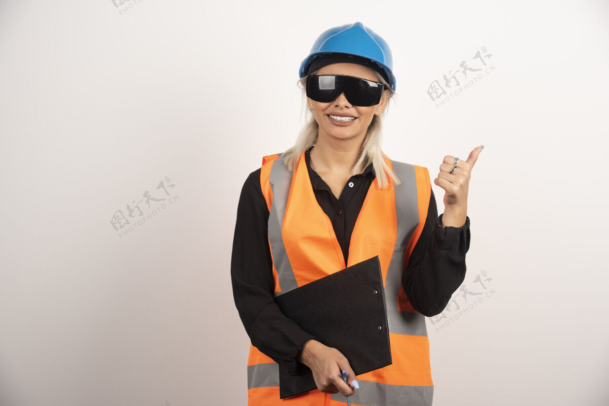 工程师戴眼镜的女工程师在白色背景上竖起大拇指高质量照片头盔微笑女人