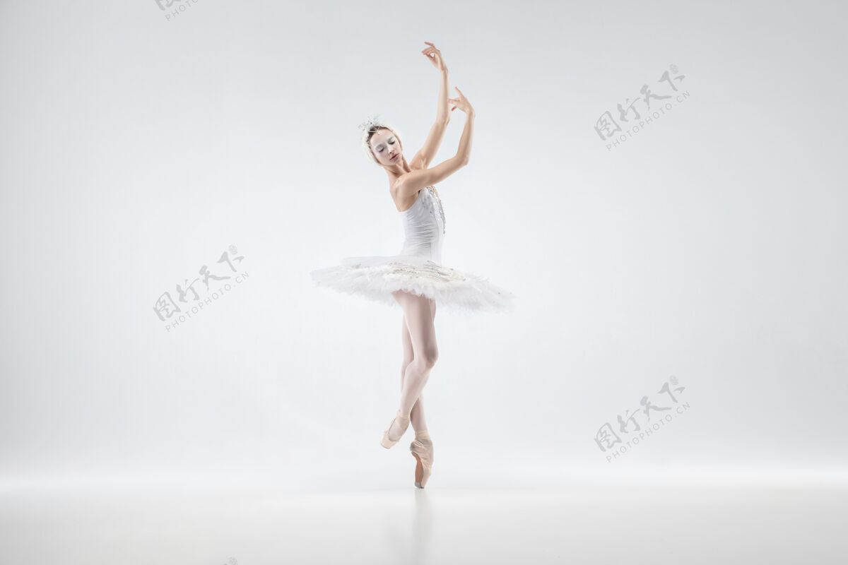 年轻以白色工作室为背景的年轻优雅的芭蕾舞演员艺术家喜悦移动