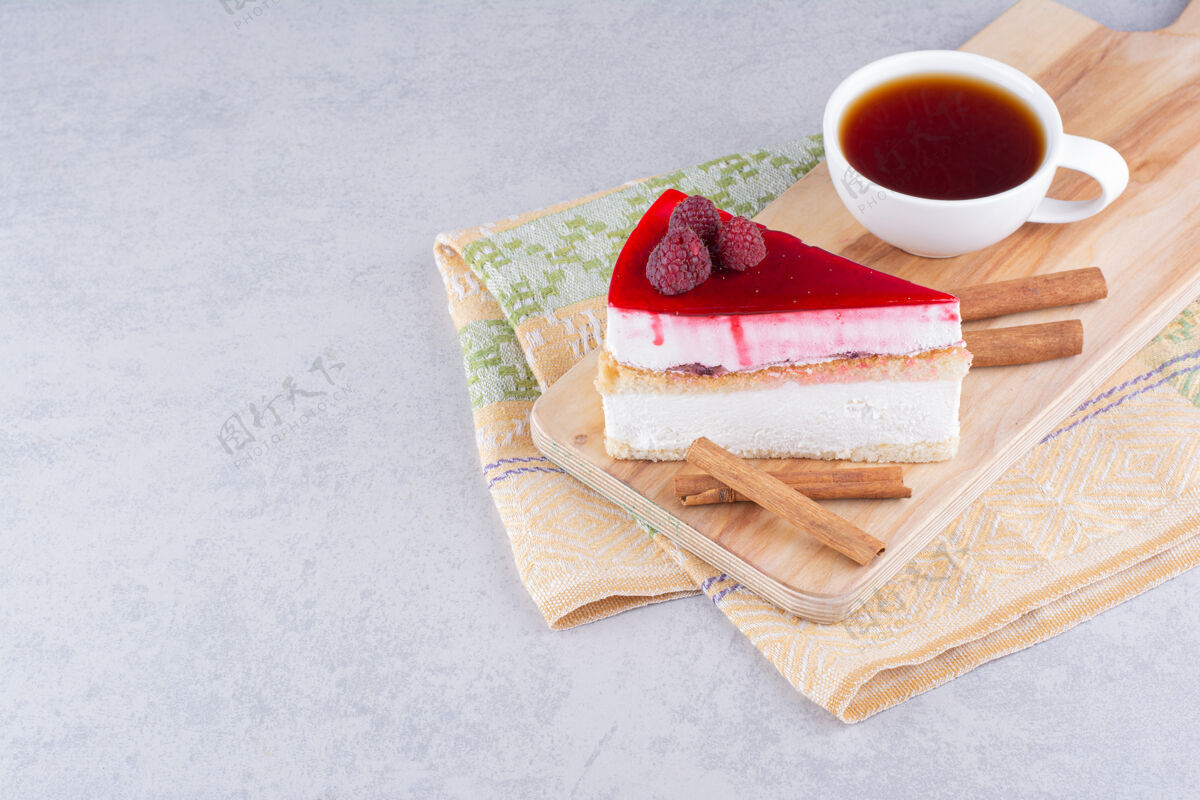 肉桂芝士蛋糕和一杯红茶放在木板上水果糕点块