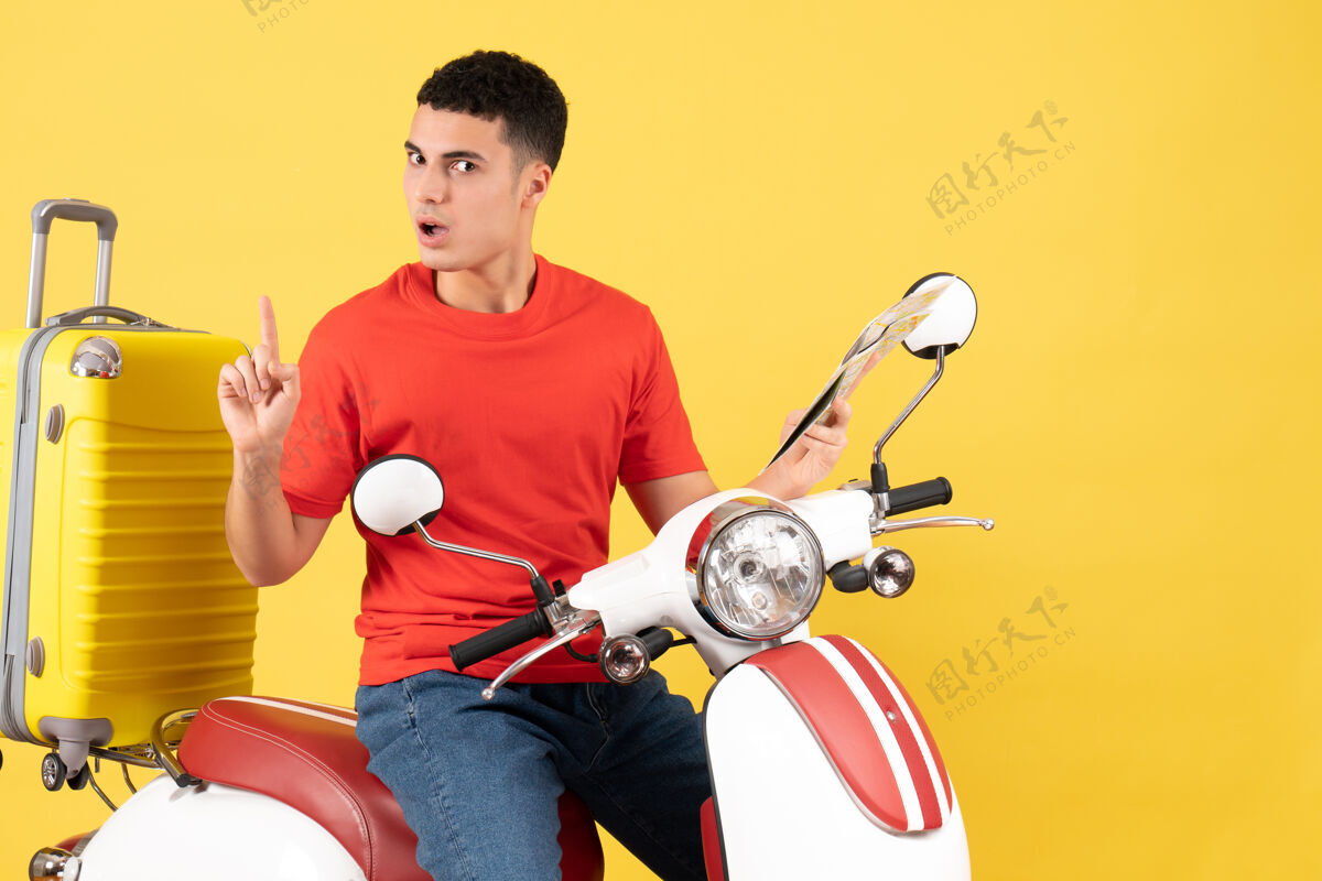 传送带前视图骑着轻便摩托车的年轻人拿着地图惊讶地想到了一个主意轻便摩托车摩托车地图