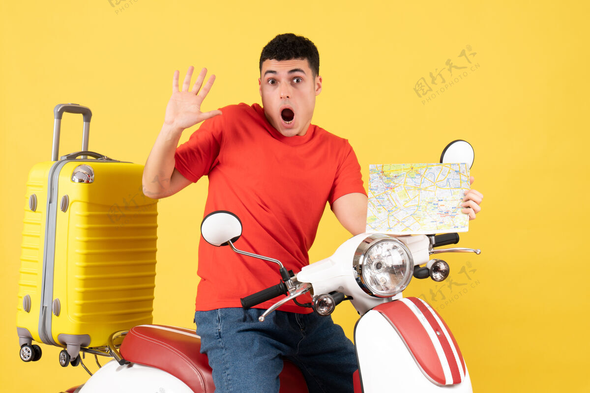 男性前景色吓坏了穿着便服的旅行男子 拿着旅游地图坐在轻便摩托车上轻便摩托车成人前面