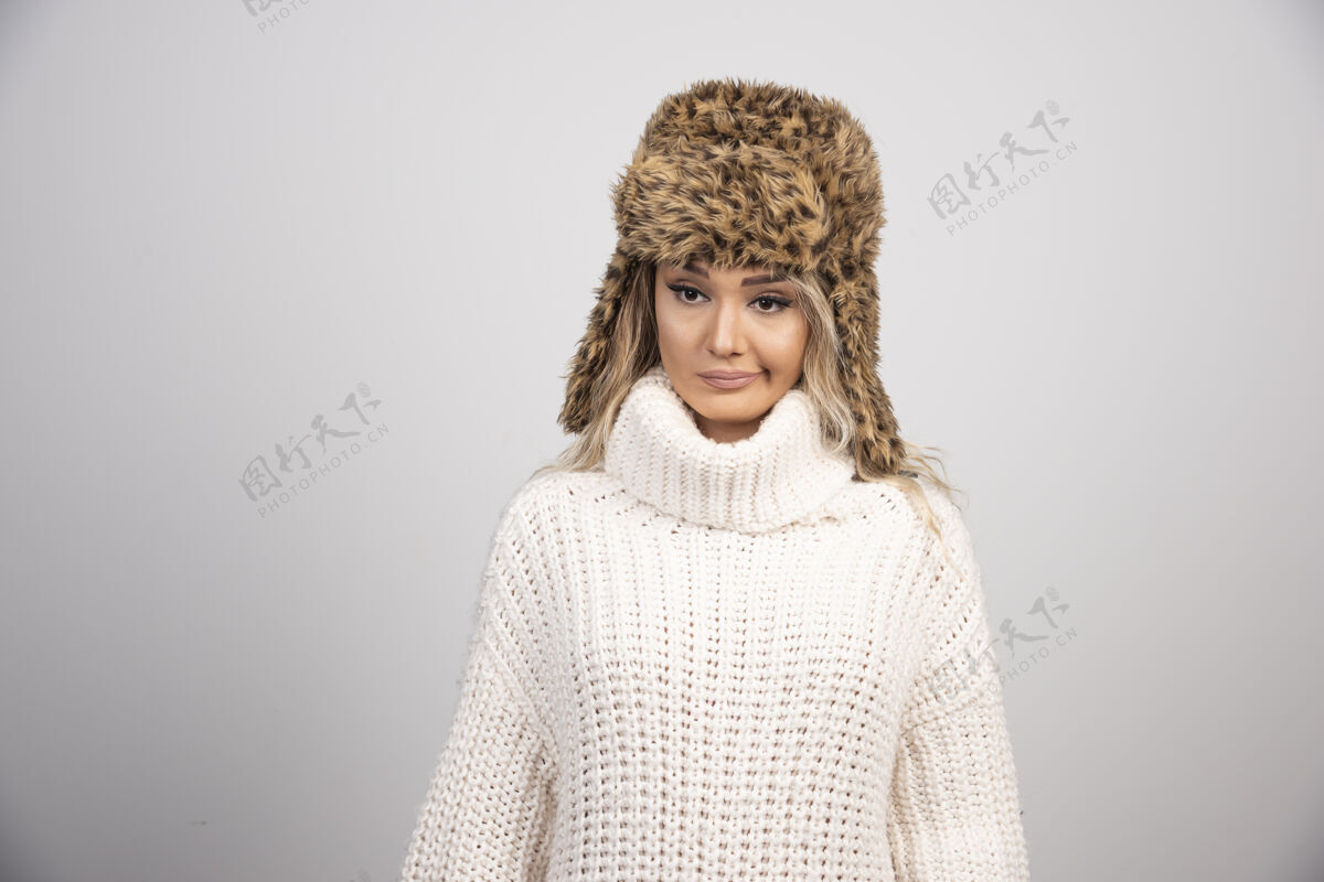 毛衣戴着冬日帽的女人在看镜头舒适帽子年轻