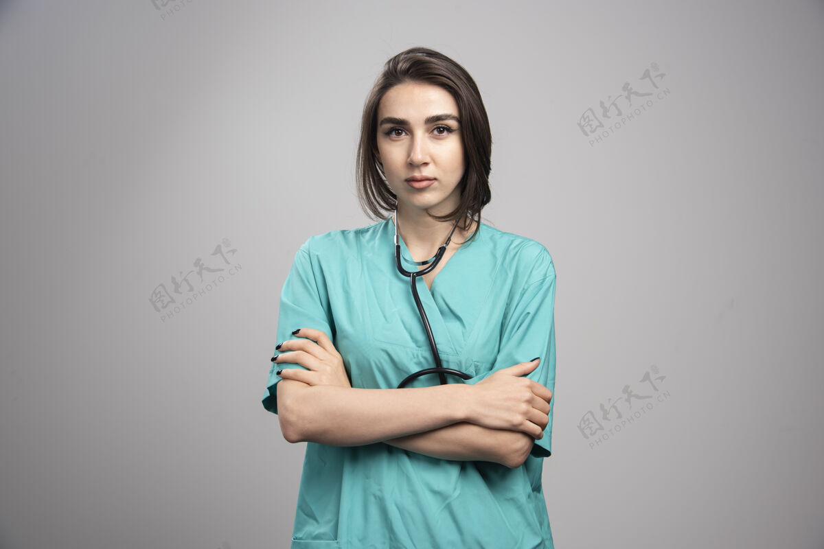 治疗带听诊器的女医生站在灰色背景上高质量照片健康个人医生