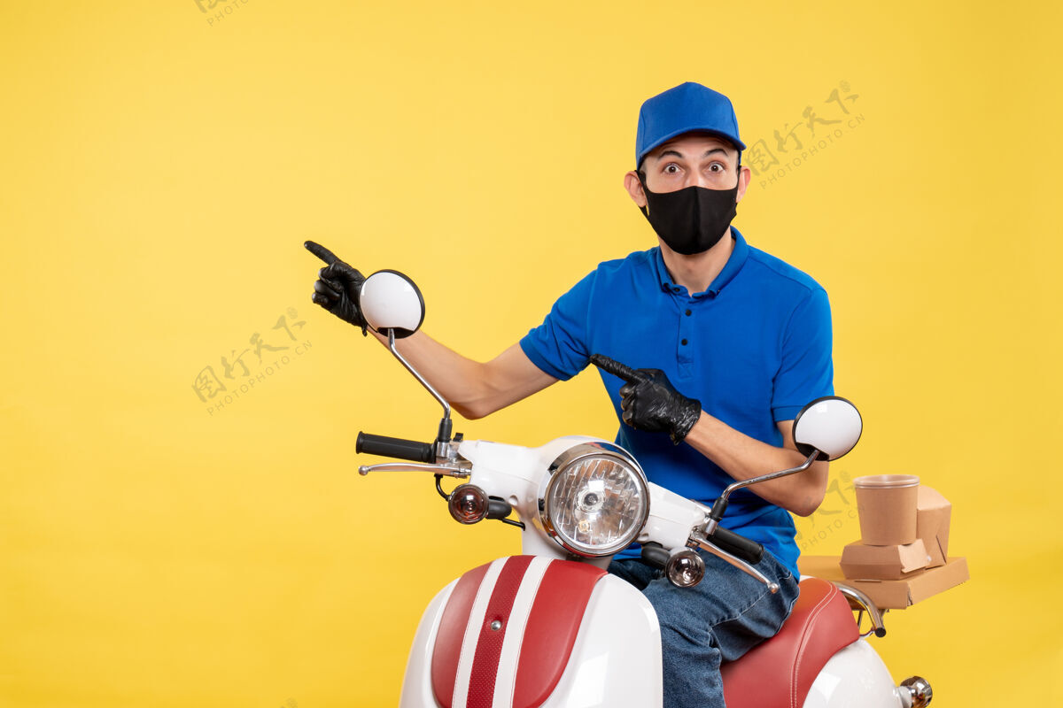 摩托车正面图黄色背景下戴着面罩骑自行车的年轻男性信使视图流行病送货