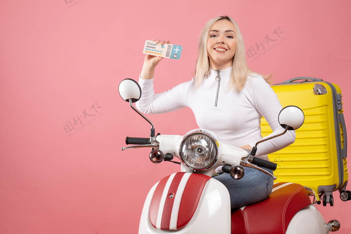 车辆正面图：坐在轻便摩托车上微笑的年轻女士出示车票摩托车微笑的年轻女士轻便摩托车