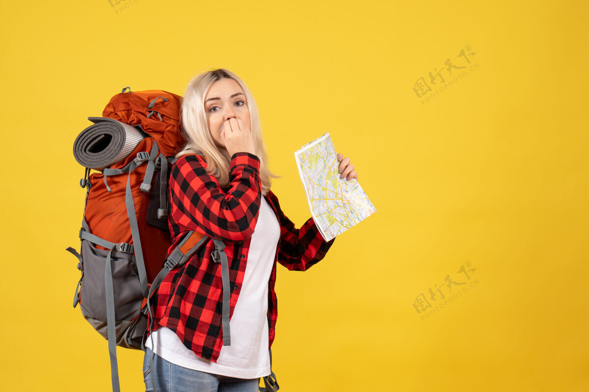 拼图前视图困惑的旅行女孩与她的背包举行地图快乐表情持有