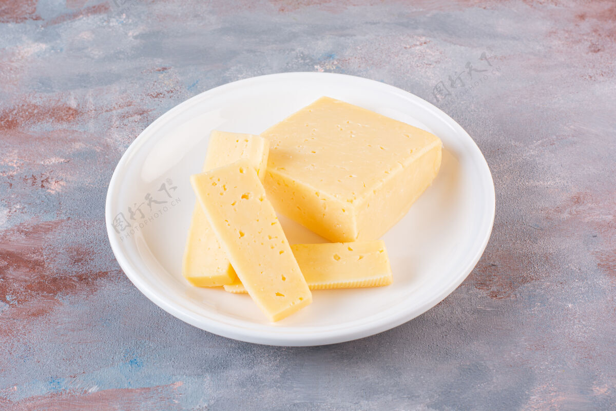 小吃白色的黄色奶酪片放在大理石表面切营养好吃