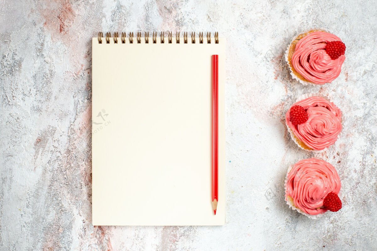 记事本白色表面上有奶油和记事本的粉色草莓蛋糕俯视图饼干古董年份