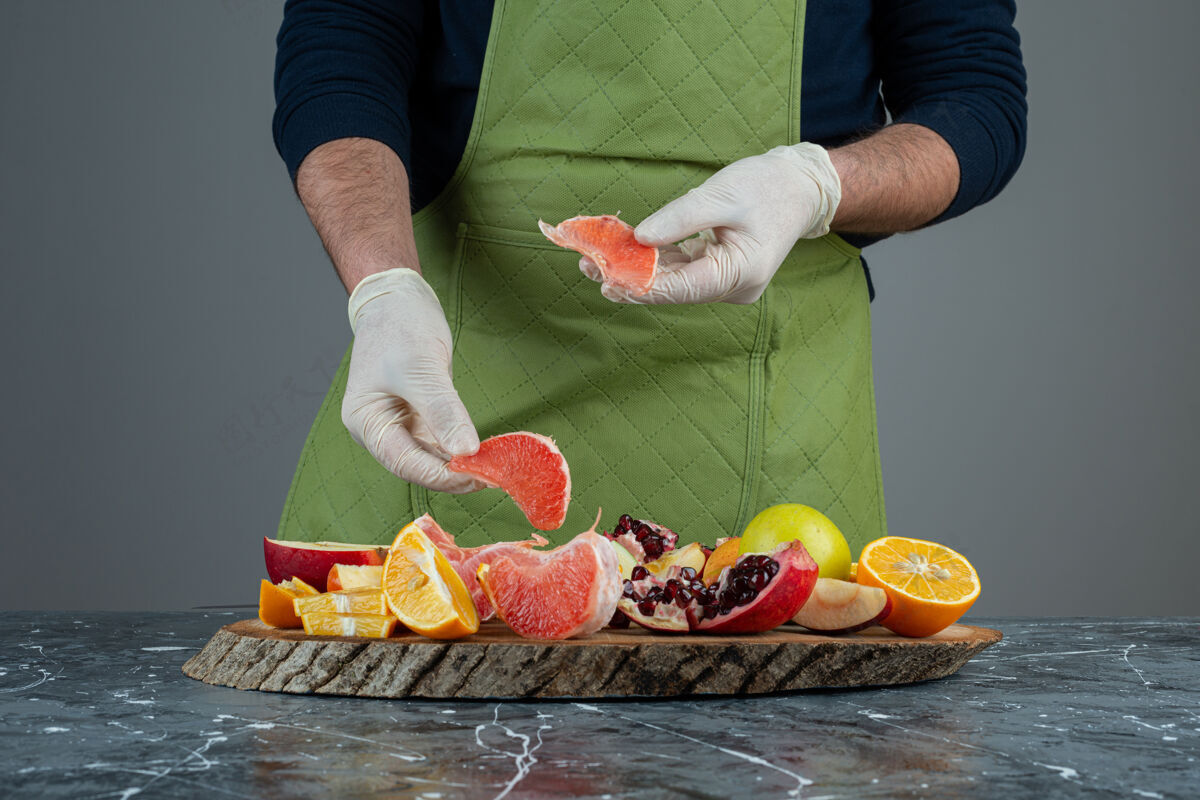 橙子男性手拿多汁的葡萄柚放在大理石桌上切片混合手